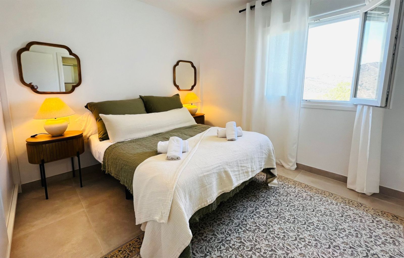 Gezellige slaapkamer in La Viñuela met groen beddengoed en zachte handdoeken.